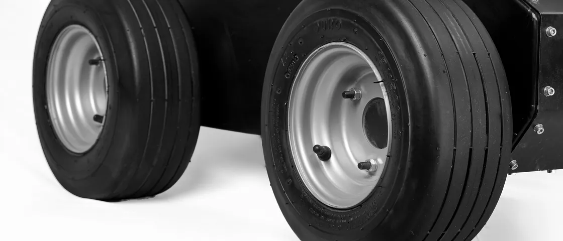 The Saibya drivetrain: solid field tyres on steel rims under a bolted, sealed chassis enclosure.